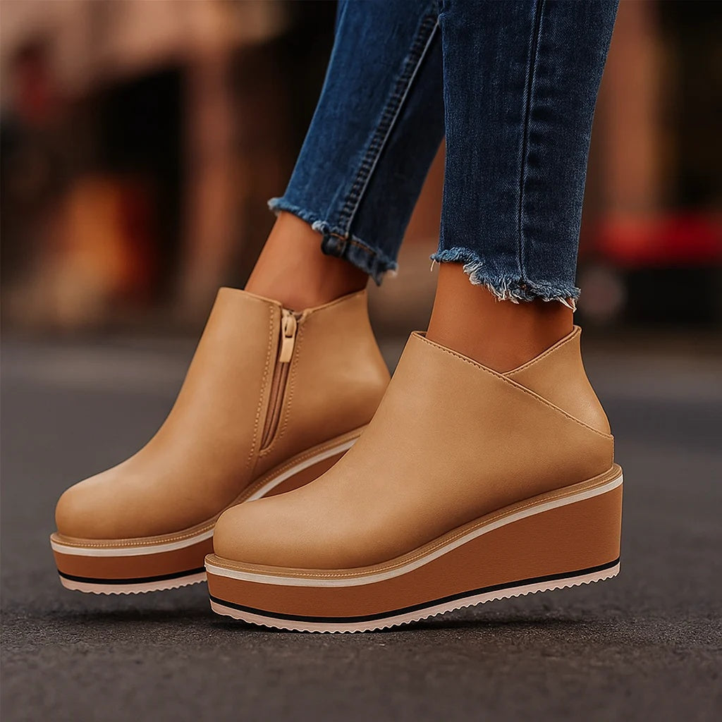 Bottines compensées Coralie de Danoir Paris avec zip latéral, en cuir beige, sur une surface en bois.