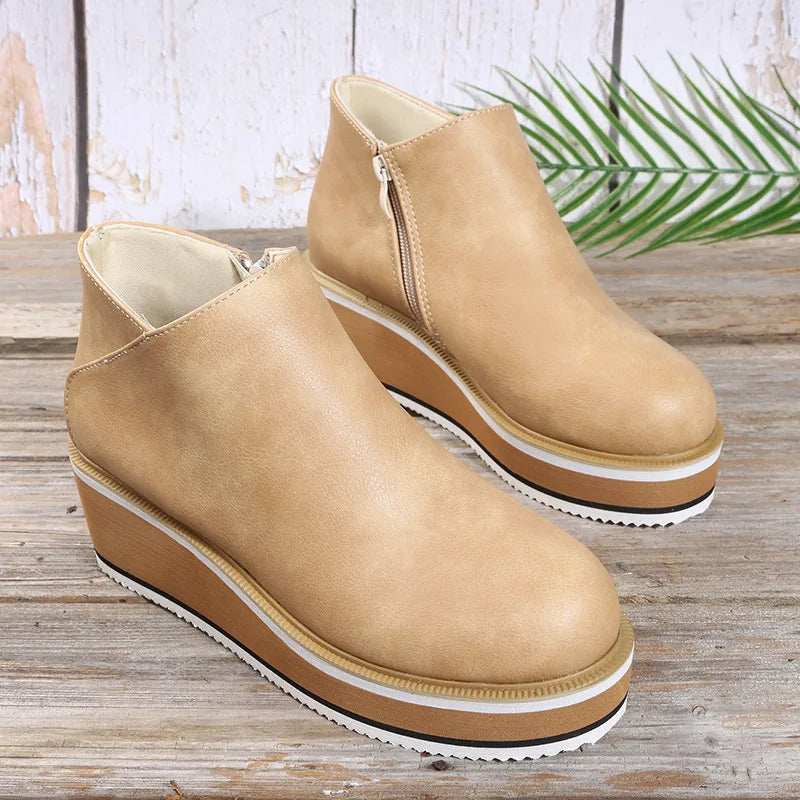 Bottines compensées Danoir Paris Coralie avec zip latéral, en cuir beige, sur une surface en bois, style moderne et élégant.