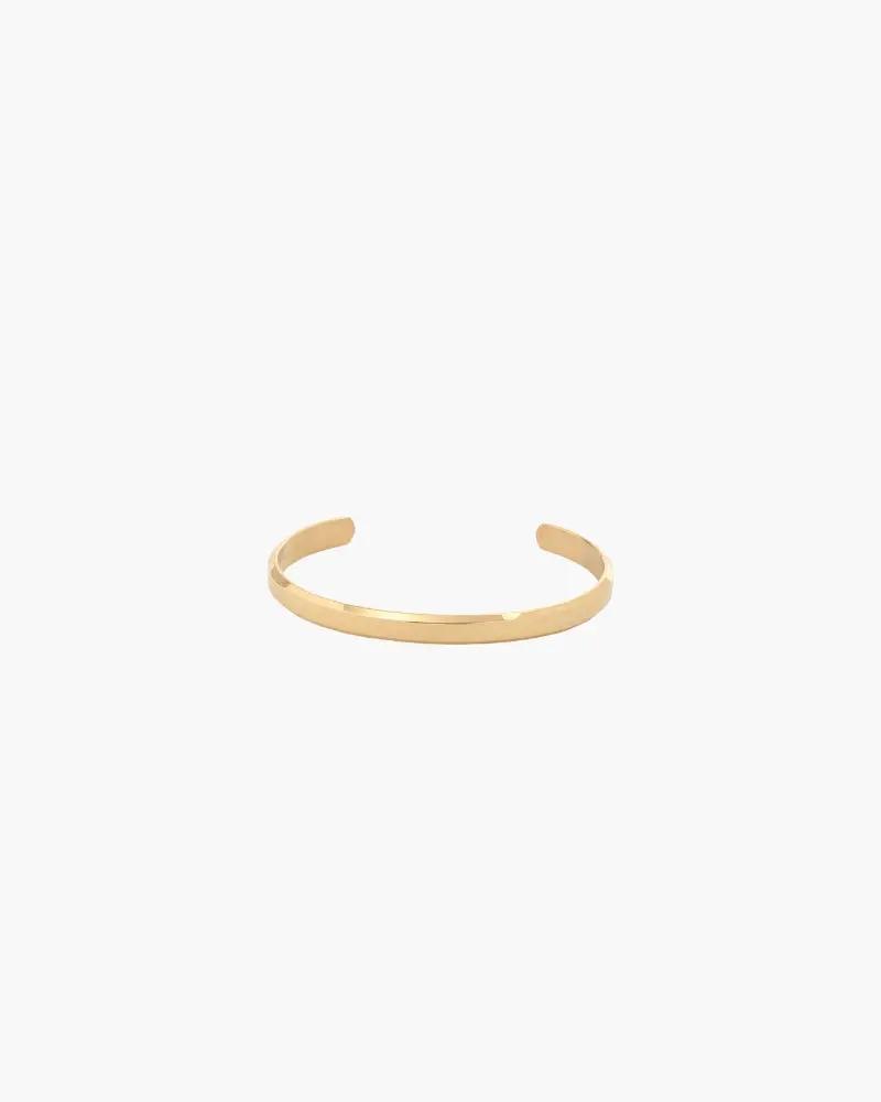 Poignet de manchette Core Cuff d'Old Money, en métal doré avec détails minimalistes, porté sur un poignet féminin.