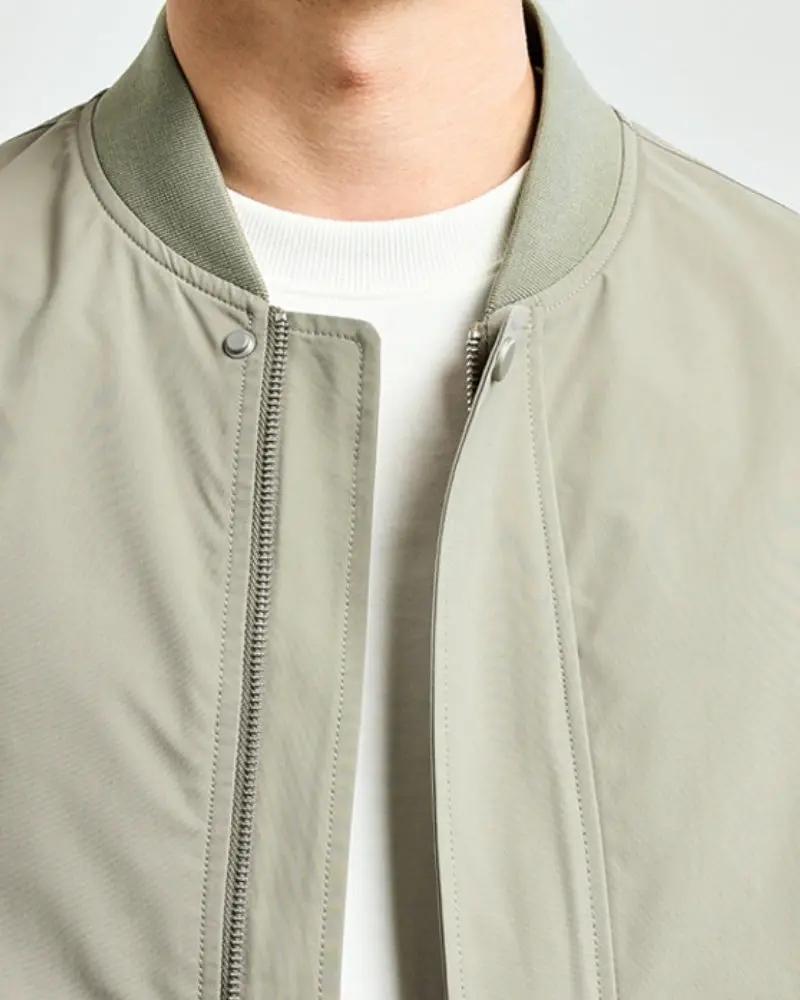 Veste bomber minimaliste Old Money, coupe épurée, en tissu noir, avec col ras du cou et poches latérales.