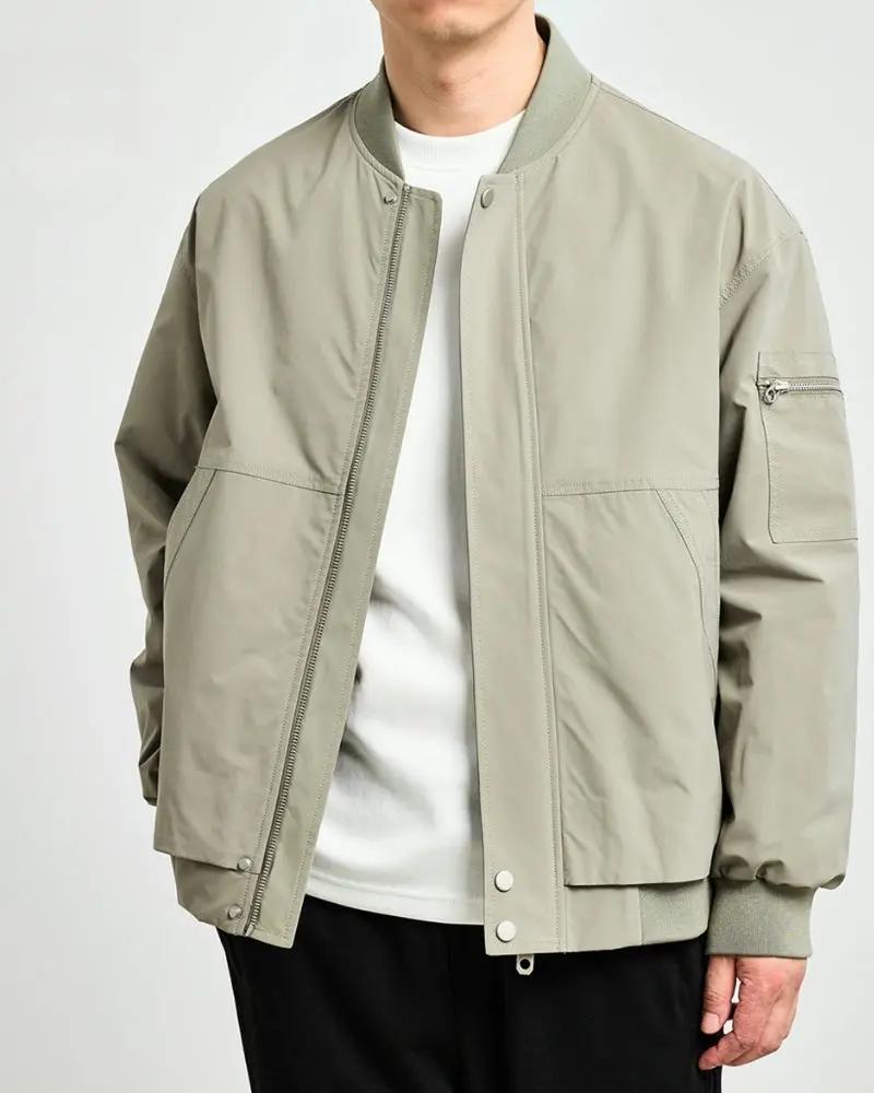 Veste bomber minimaliste de la marque Old Money, en tissu noir avec poches et col ras du cou, vue de face.
