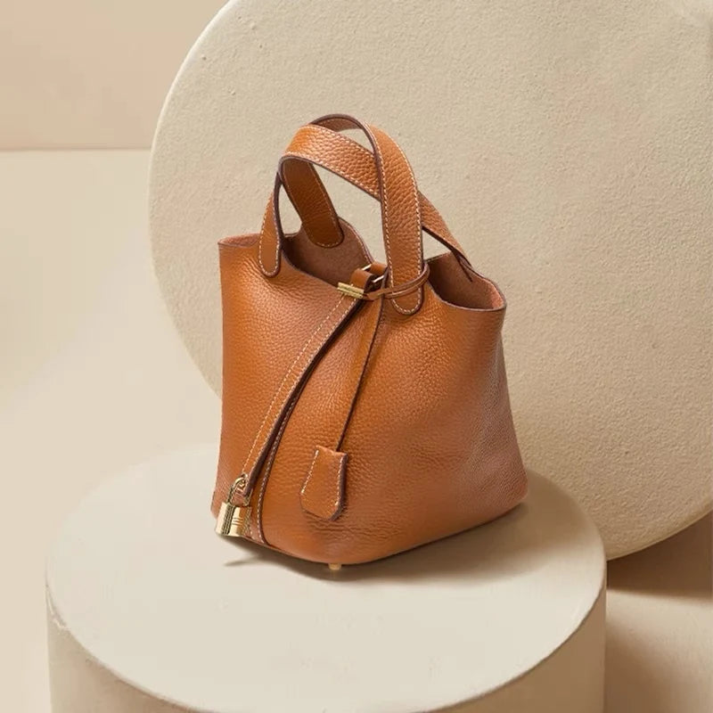 Sac seau orange Danoir Paris, sac à main en cuir avec bandoulière, vue de face avec détails de la texture.