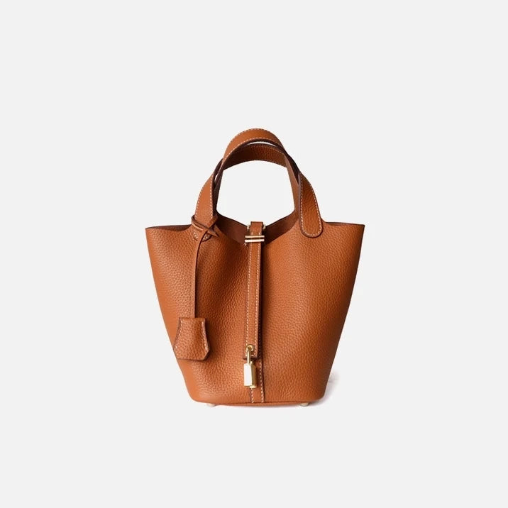Sac seau orange Danoir Paris, en cuir, avec poignée en chaîne, prêt à être porté.