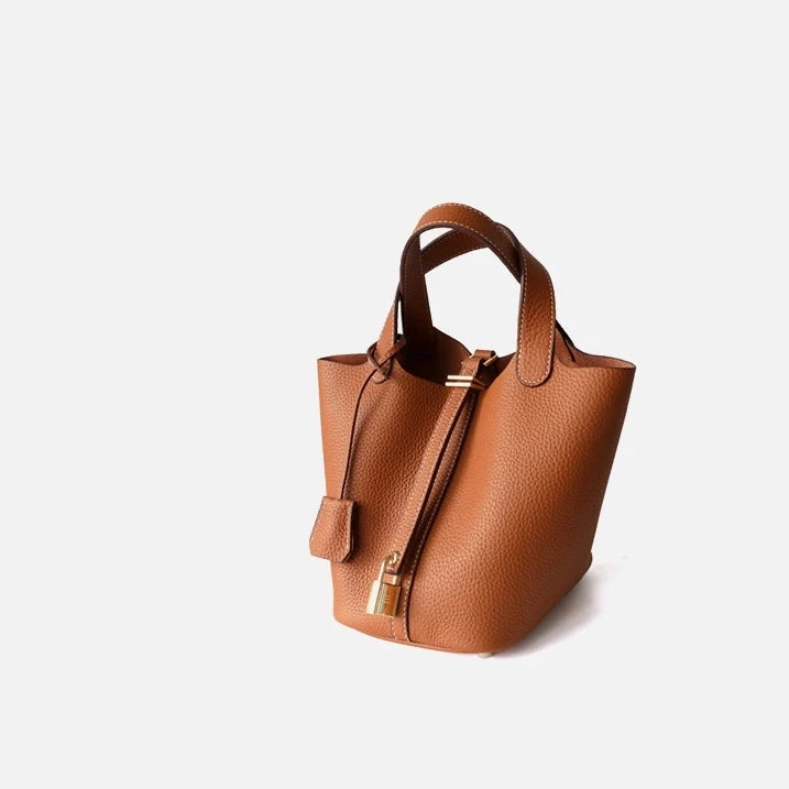 Sac seau Portico de Danoir Paris en orange, avec design moderne et poignée en cuir, idéal pour un look chic et pratique.