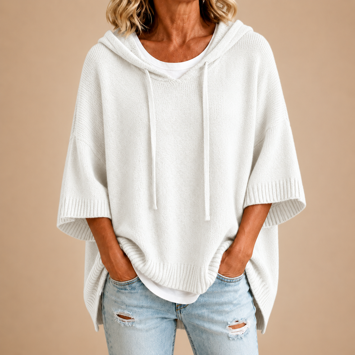 Poncho en maille blanche avec capuche de la marque Danoir Paris, vêtement chaud et décontracté pour l'automne et l'hiver.