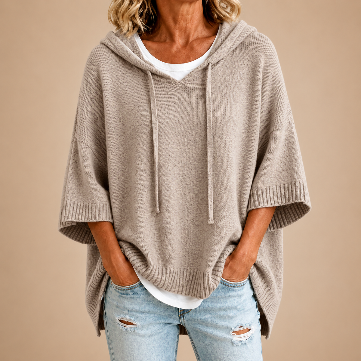 Poncho en tricot taupe avec capuche de la marque Danoir Paris, élégant et confortable, porté en studio.