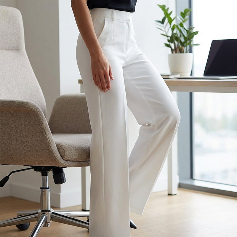 Pantalon de costume pour femmes taille haute Danoir Paris, coupe élégante en tissu noir, porté avec une blouse blanche.