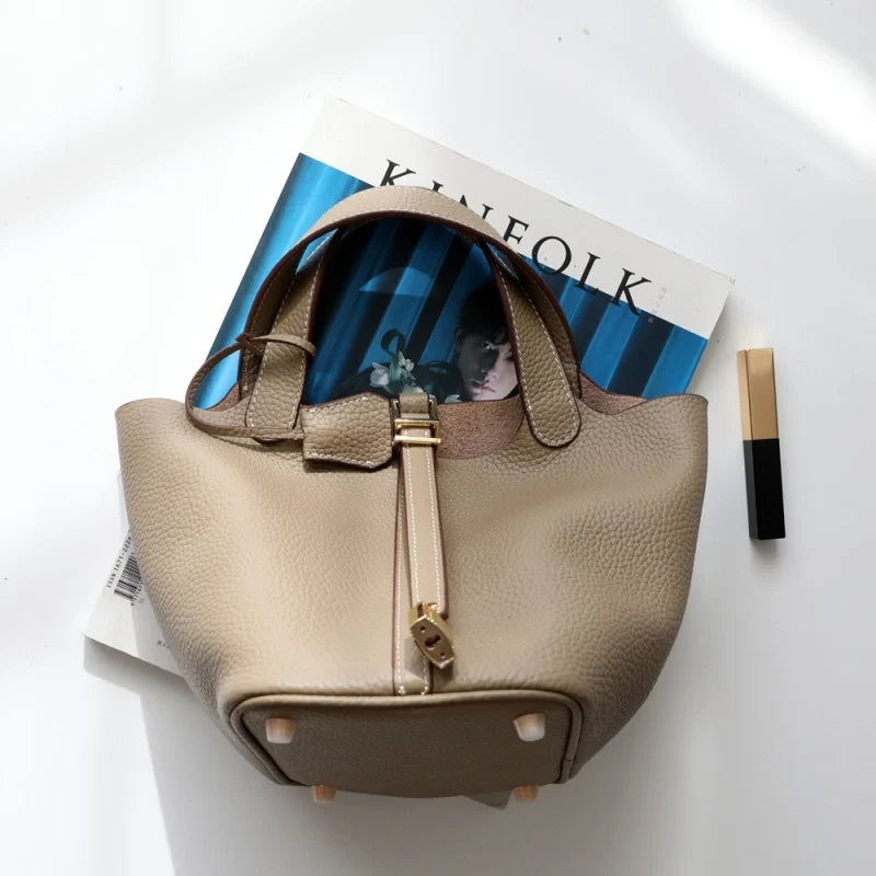 Sac seau Danoir Paris Portico en taupe avec poignées en cuir et design élégant visible sur l'image.