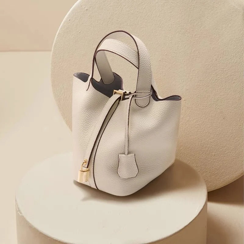 Sac seau Portico Danoir Paris blanc en cuir avec bandoulière et fermeture à cordon, élégant et pratique.